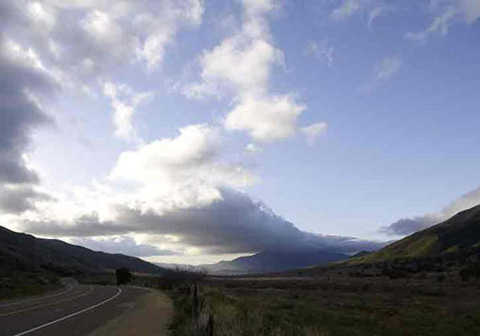South-facing photo showing storm clouds coming from the west and breaking up when the hit the mountains beside the desert